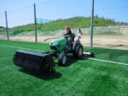 スポーツトラクターで人工芝の目を立てる