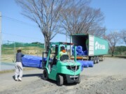 コンテナより荷下ろしされる人工芝