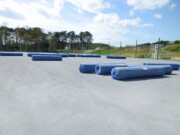 グラウンドに荷下ろしされた人工芝ロール